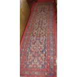 A Persian woollen blue ground Tabriz long hall runner, the floral geometric central ground within