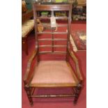 An Arts & Crafts walnut reeded ladderback elbow chair, having upholstered cushion seat, w.