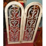 A pair of contemporary lime-washed pine French style arched wall mirrors, with wired metal scroll