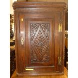 An early 19th century provincial relief carved oak single door hanging corner cupboardHeight 88cm,