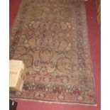 A Persian woollen red ground Tabriz rug, having a heavy floral stylised trailing ground within