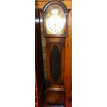 A 1920s oak Tempus Fugit longcase clock, having arched silvered dial with brass spandrels, oval