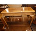 A 1930s figured walnut and crossbanded fold-over card table, raised on shell capped slender cabriole