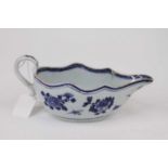 A 18th century Chinese blue and white porcelain saueboat, having a wavy rim and scroll handle (a/f)