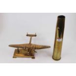 A WWII 40mm brass shell case; together with a brass model of a Lancaster Bomber on an associated