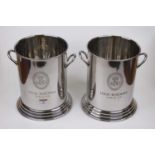 A pair of polished metal twin handled wine coolers of cylindrical form, each on a stepped circular