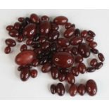 A collection of cherry amber barrel beads, formally from a necklace and for re-stringing, the