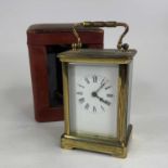 An early 20th century lacquered brass cased carriage clock, having an enamel dial with Roman