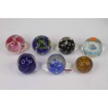Seven coloured glass paperweights, to include Millefiore example