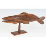 A 20th century Pitcairn Islands carved miro wood model of a flying fish, the left wing carved "