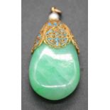 A nephrite pendant, on filigree worked gilt metal mount and topped with a cultured pearl, 14.9g, h.