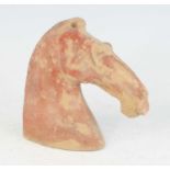 A Chinese Six-Dynasties period (220-589) earthenware funerary horse's head, red painted pigment, h.