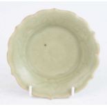 A Chinese Ming period (1368-1644) pale green celadon decorated small lotus dish, the raised and
