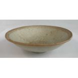 A Chinese Tang Dynasty (618-907) pale celadon stoneware footed dish, of ribbed shallow form, with