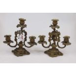 A pair of gilt metal three sconce table candlesticks in the Rococo style, height 26cm