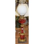 A Victorian style oil lamp, having an opalescent globular shade above a cranberry glass font with