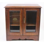 An Edwardian oak smokers cabinet, fitted with two short drawers and a pipe rack, enclosed by a