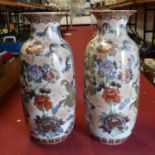 A pair of large Japanese style vases, each having an everted rim to a baluster body with raised