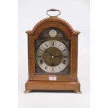 An 18th century style walnut cased bracket clock having a brass arched dial with silvered chapter