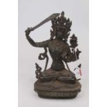 A reproduction hollow cast spelter model of a Tibetan deity in seated lotus pose with blue & red