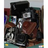 A box of various cameras, camera related equipment and accessories
