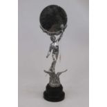 An Art Deco style figural circular mirror supported by a figure of Victory with torch in hand,