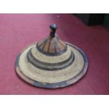 A South East Asian woven wide brimmed hat, having a leather banded rim and adjustable leather chin