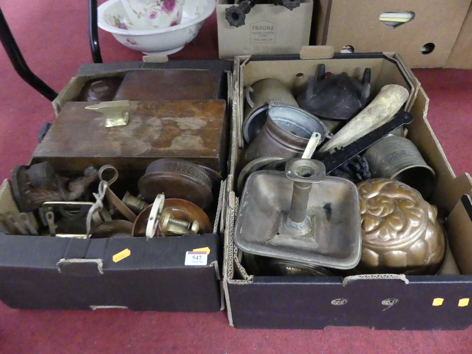 Two boxes of metalware to include chambersticks, copper saucepans, and jelly moulds