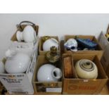 A collection of oil lamps, shades and pottery