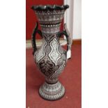 A Persian style vase, having a frilled everted rim to a slender neck and bulbous lower body with