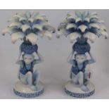 A pair of reproduction Chinese resin candlesticks, each having a three-tier leaf sconce supported by