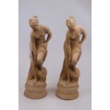 A near-pair of reconstituted stone figures, each in the form of a semi-nude classical maiden in
