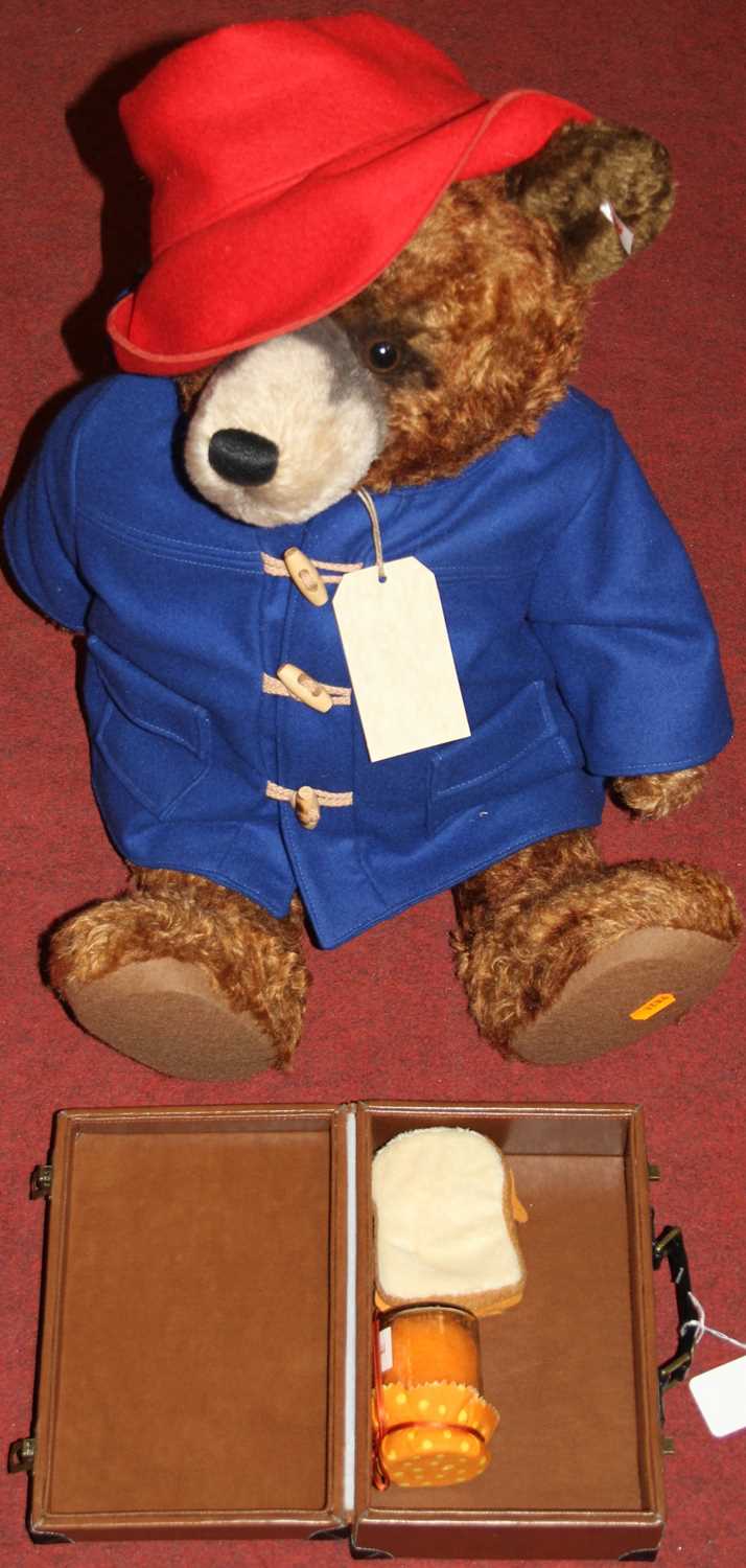 A large Steiff Paddington Bear in brown mohair with red hat, blue duffle coat with button and