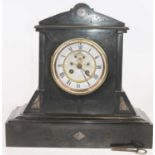 A late Victorian black slate cased mantel clock, having a circular enamelled chapter ring with Roman