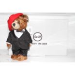 A Steiff mohair bear in red hat and black suit label with button to ear and white label number