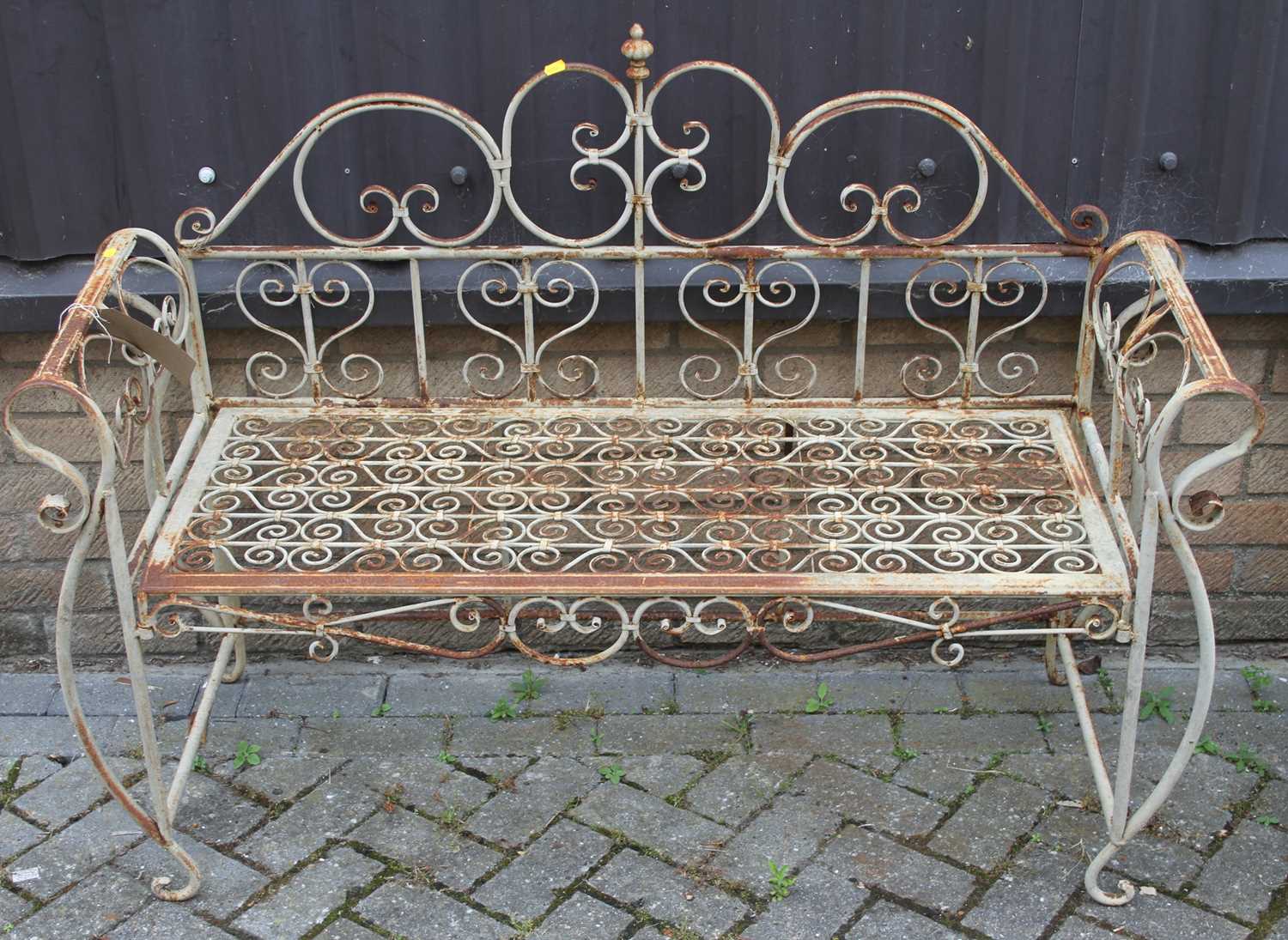 A wrought metal floral scroll decorated two-seater garden bench, width 129cmSolid and stable, but