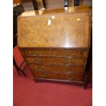 A mid 20th century figured walnut and crossbanded four drawer slopefront writing bureau, width 80cm