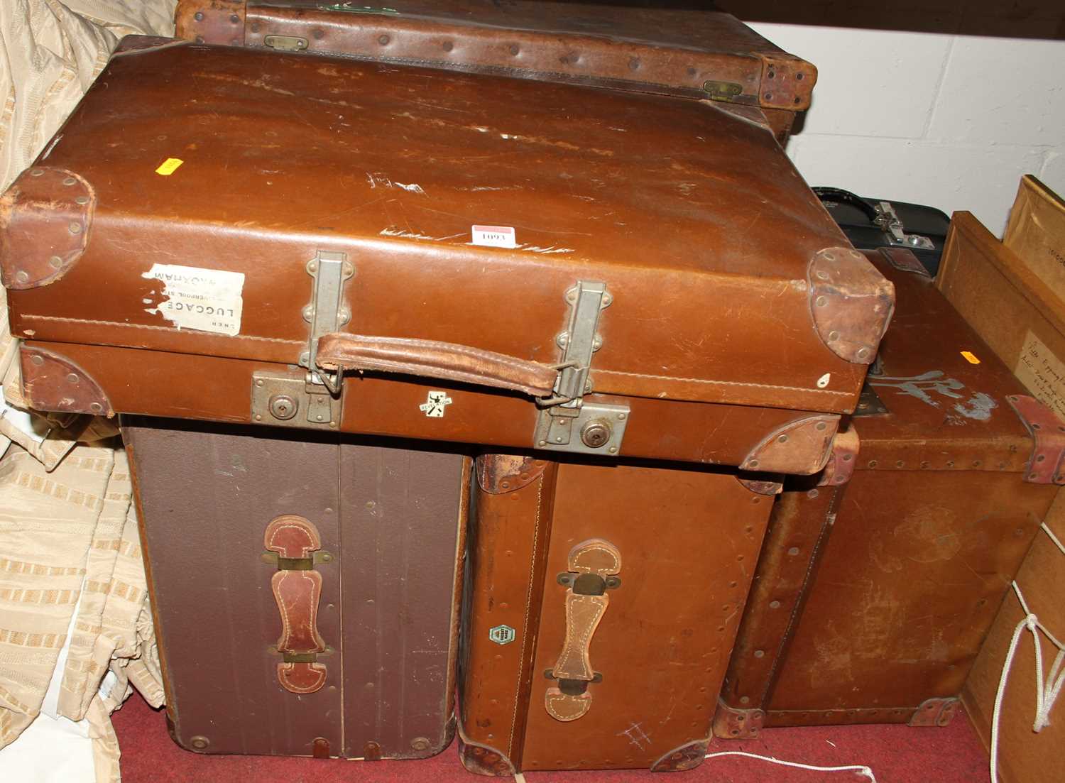A collection of sundry vellum and canvas suitcases, travelling trunks etc