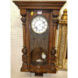 An early 20th century walnut droptrunk wall clock, with pendulum