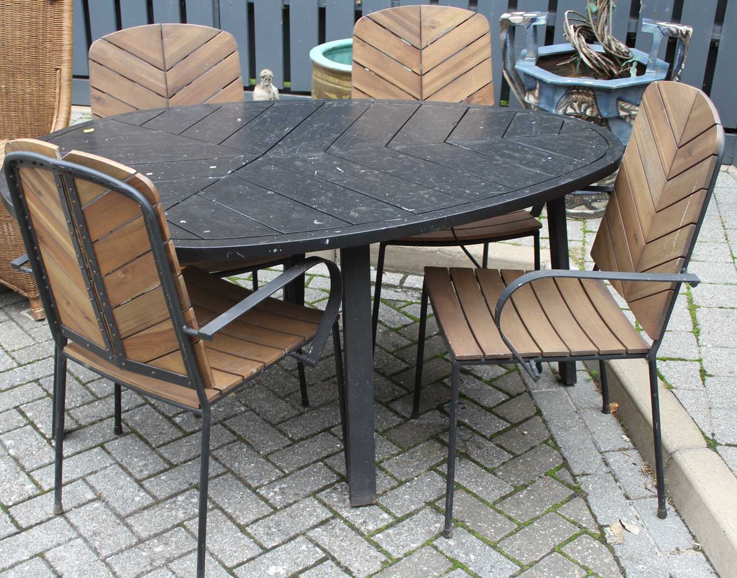 A contemporary black painted hardwood and wrought metal patio suite comprising; leaf shaped table