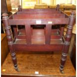 A 19th century mahogany three-division Canterbury, raised on ring turned supports to castors,