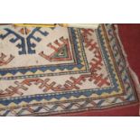 A Turkish woollen cream ground rug, 245 x 152cm