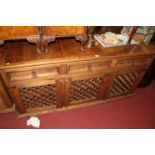 An Eastern stained reclaimed pine and metal bound three-door sideboard, having three conforming