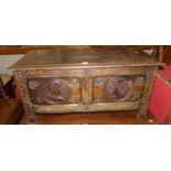 A mid-20th century line carved oak twin panelled blanket chest, each panel with Monarchs portrait