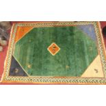 A Turkish woollen green ground carpet, having abstract stylised geometric decoration to conforming