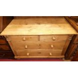 A pine low chest of two short over two long drawers, on bun supports within reeded detail, width