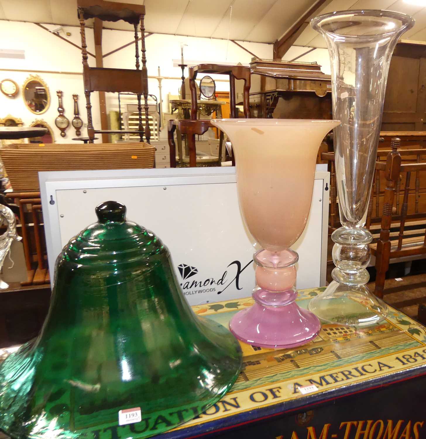 A green moulded glass bell shaped cloche, together with a heavy pink cased glass knopped pedestal
