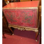 A 1930s and later red painted and gilt decorated double door drinks cabinet, raised on scroll