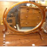 A mahogany oval swing dressing mirror