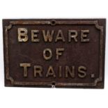 An original mid 20th century cast iron 'Beware of Trains' sign, white on black example, 55x38cm